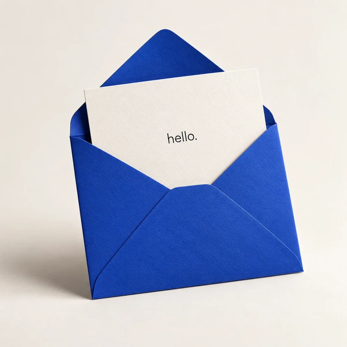 Royal blue envelope with a white hello card on a soft neutral background